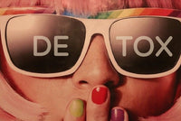 Sia looking gal with pink hair and rainbow glasses and different colored fingernails sporting detox on her sunglasses. 